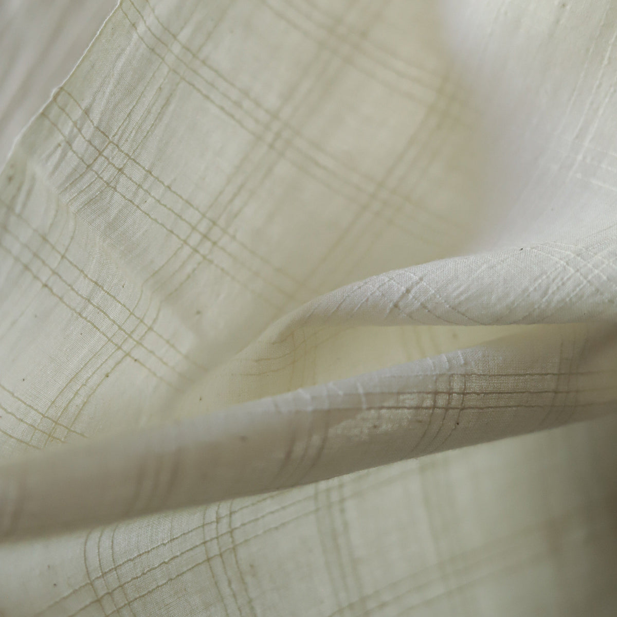 Close-up of off white handwoven pure cotton khadi fabric of West Bengal with subtle texture