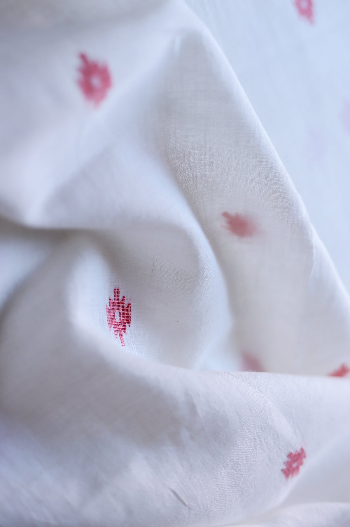 Close-up of white fabric with red floral patterns