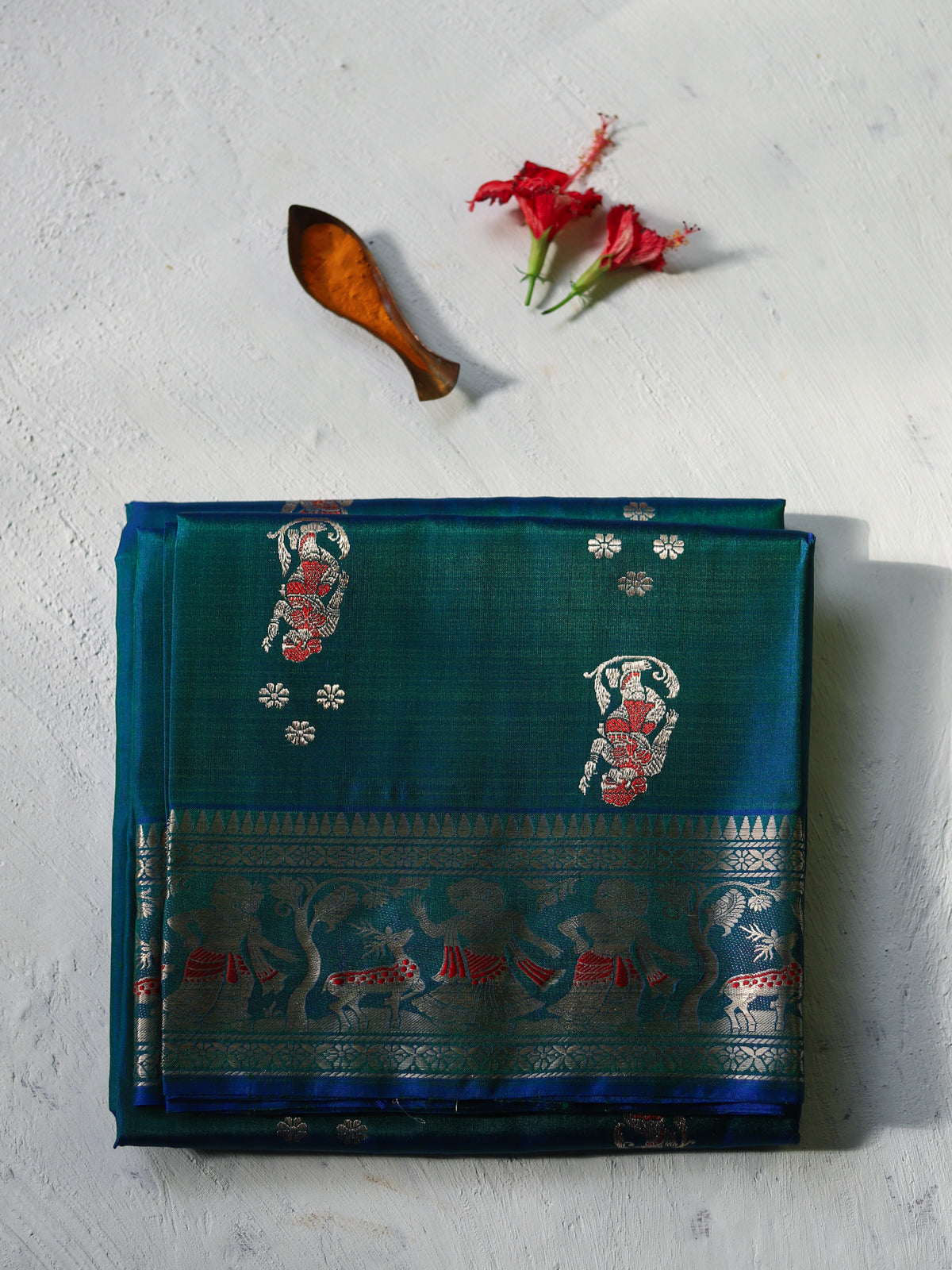 Handwoven Swarnachari Mulberry silk wedding saree for bengali bride in Teal saree with intricate patterns on a light gray background