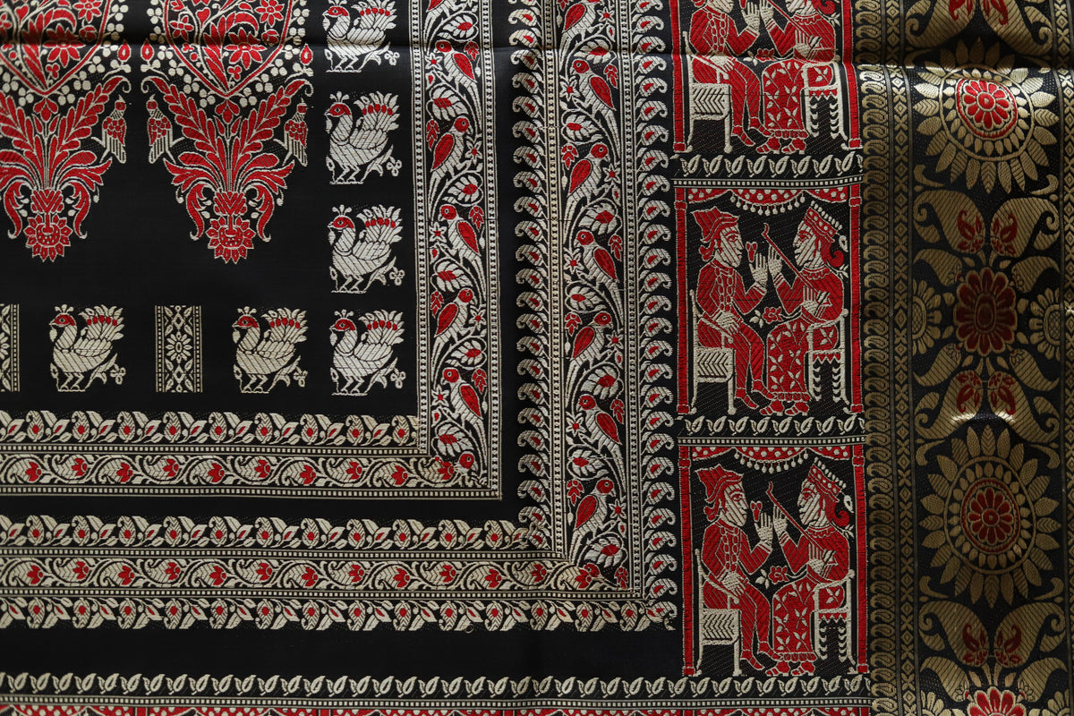 Decorative fabric with intricate patterns in red, black, and gold.