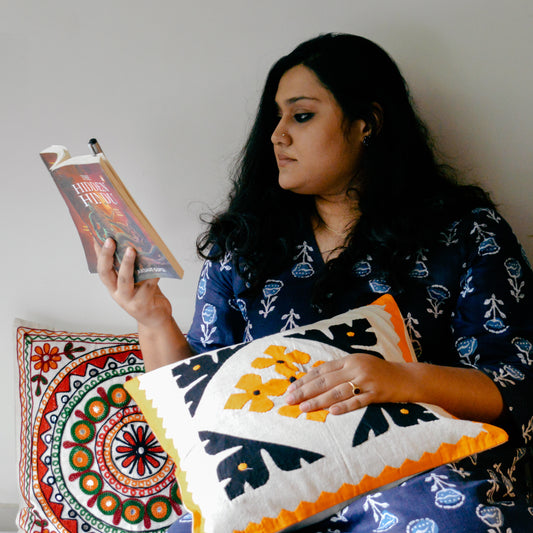 Sitting diwan decorative with multicolour embroidered cushion cover in a living room setting