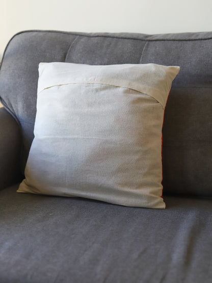 Beige pillow on a gray sofa against a white wall