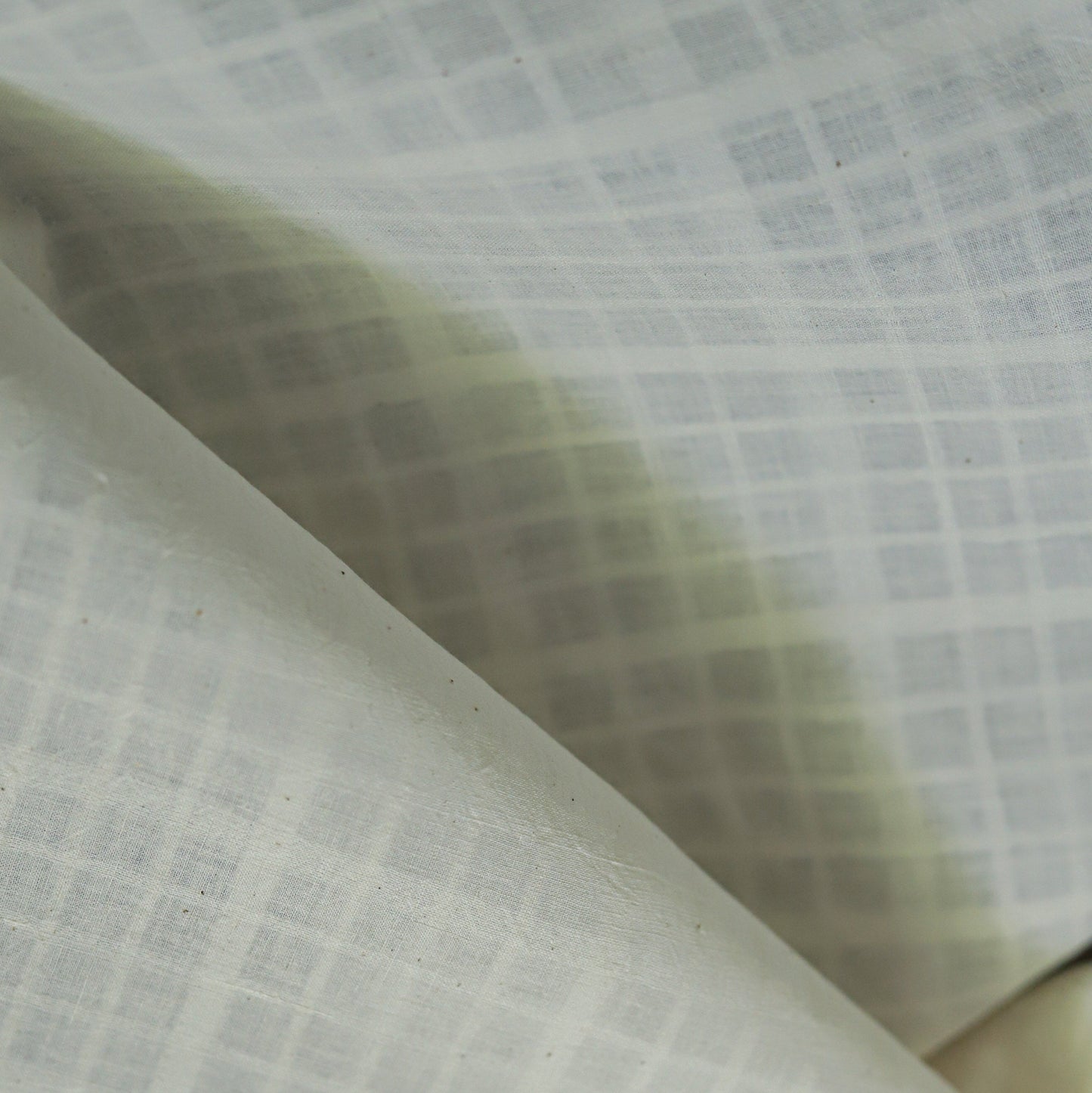 Close-up of textured handwoven khadi  fabric with a grid pattern
