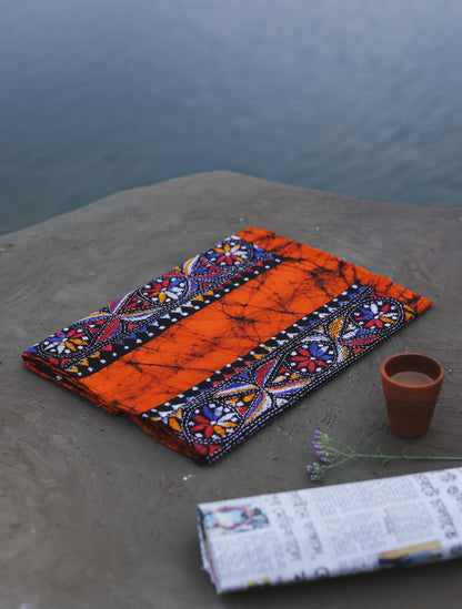 Decorative Batik Kantha Cotton Kurta Fabric with geometric pattern on a stone surface next to a cup of coffee and rolled-up newspaper.