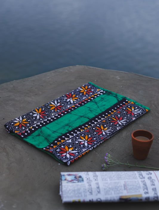 Decorative Batik Kantha Cotton Kurta Fabric with geometric pattern on a stone surface next to a cup of coffee and rolled-up newspaper.