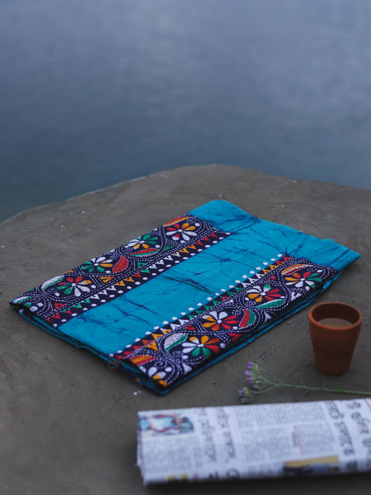 Decorative Batik Kantha Cotton Kurta Fabric with geometric pattern on a stone surface next to a cup of coffee and rolled-up newspaper.