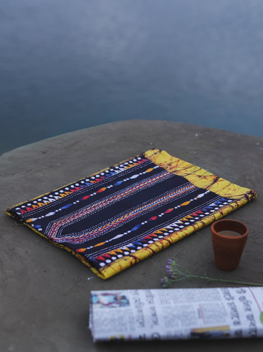 Decorative Batik Kantha Cotton Kurta Fabric with geometric pattern on a stone surface next to a cup of coffee and rolled-up newspaper.