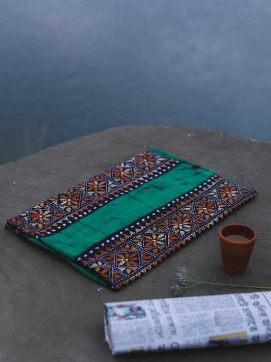 Decorative Batik Kantha Cotton Kurta Fabric with geometric pattern on a stone surface next to a cup of coffee and rolled-up newspaper.