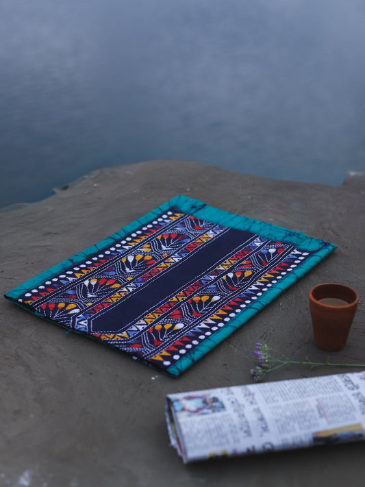 Decorative Batik Kantha Cotton Kurta Fabric with geometric pattern on a stone surface next to a cup of coffee and rolled-up newspaper.