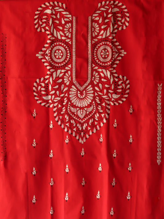 Red fabric with intricate white embroidery patterns