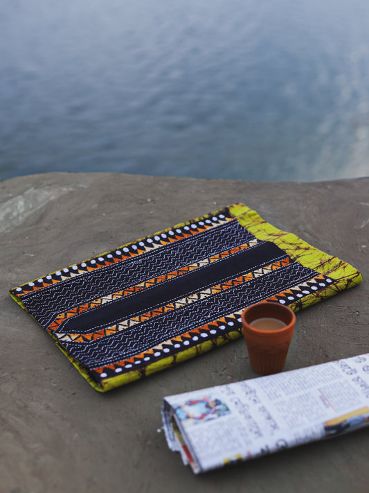 Decorative Batik Kantha Cotton Kurta Fabric with geometric pattern on a stone surface next to a cup of coffee and rolled-up newspaper.