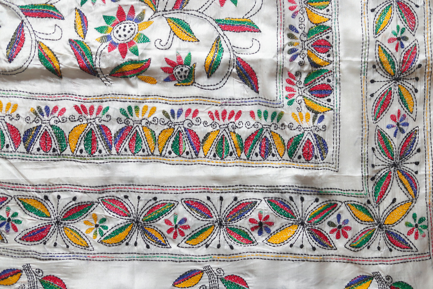 kantha Embroidered saree with colorful floral and leaf patterns on a white background
