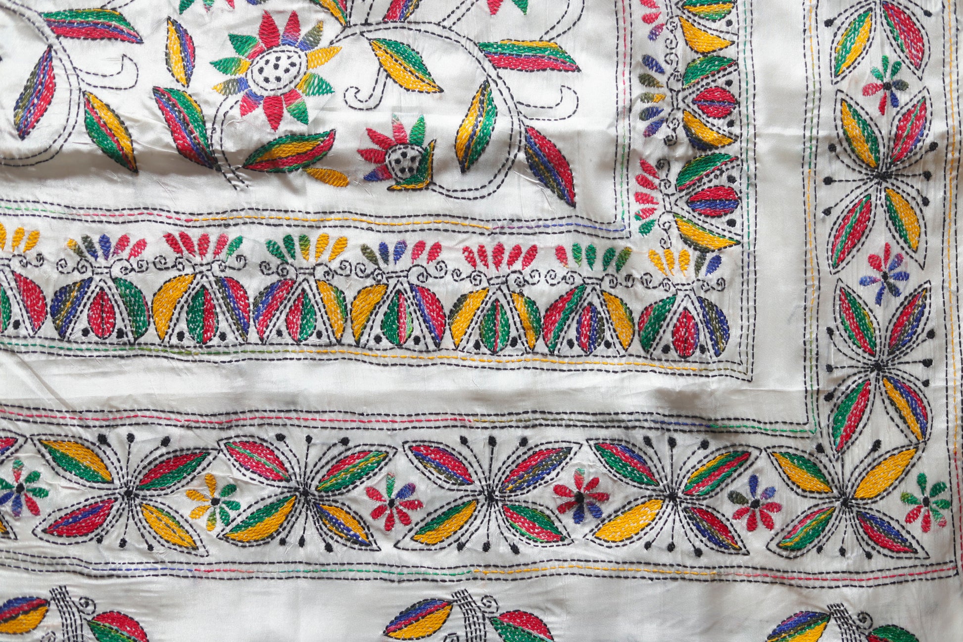 kantha Embroidered saree with colorful floral and leaf patterns on a white background