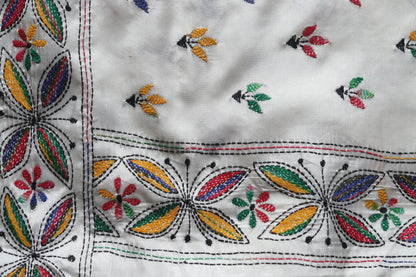 Close-up of kantha embroidered saree  with colorful patterns on a white background