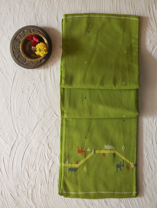 Green fabric with embroidered designs on a textured white surface