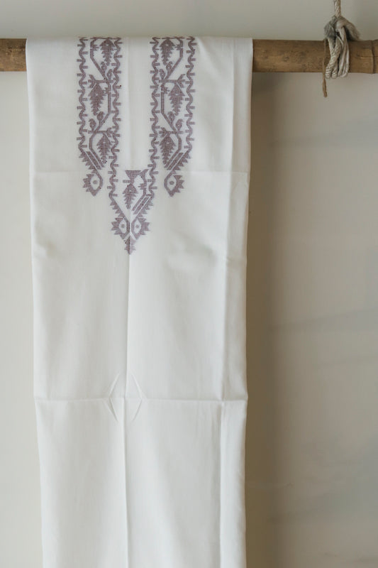 hand woven pure muslin cotton fabric of West Bengal hanging on a wooden rod against a white wall.