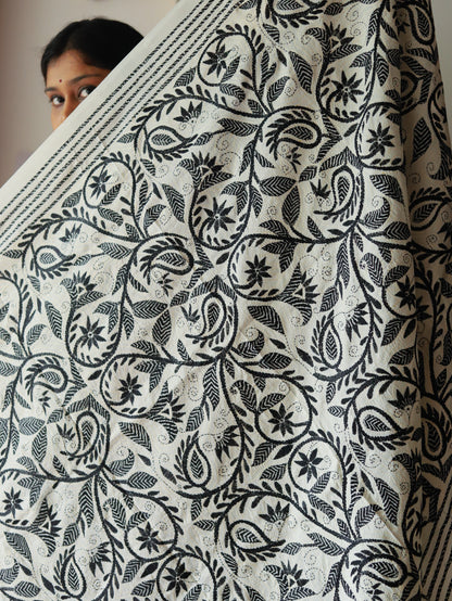 Person holding a large piece of fabric called dupatta with black floral pattern on white background