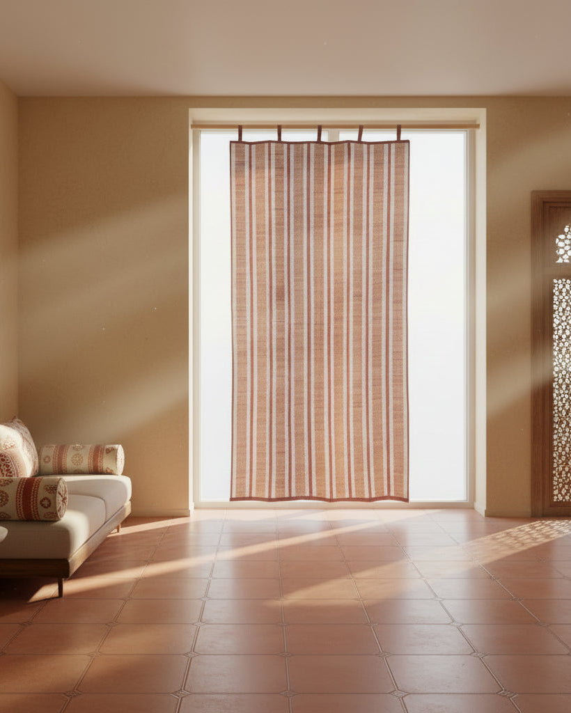 Living room with a couch, table, and large window with a curtain.