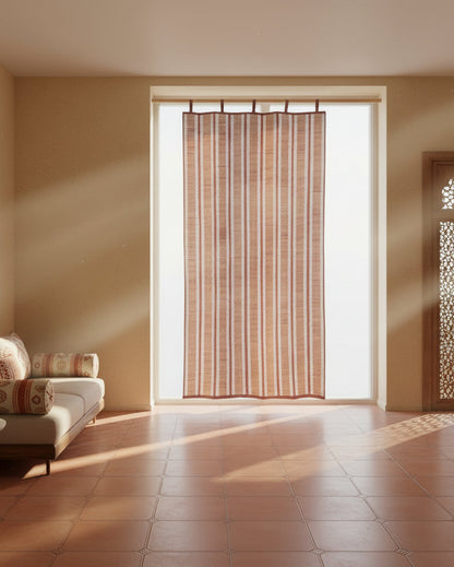 Living room with a couch, table, and large window with a curtain.